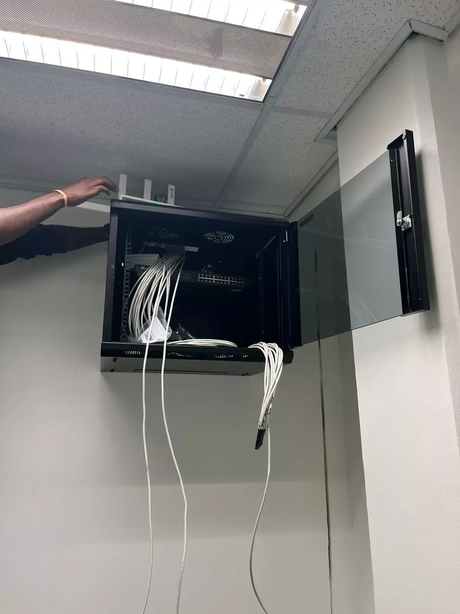 Network server rack with ethernet cables being installed on a wall
