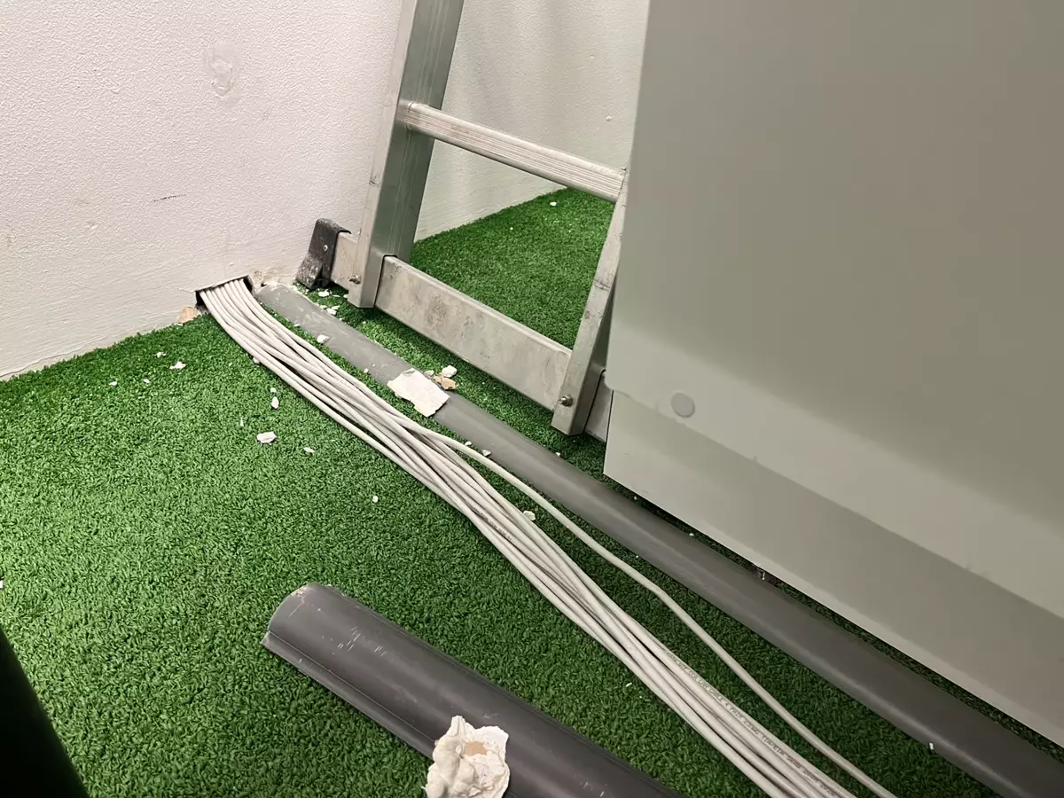 Electrical cables and a ladder on artificial grass